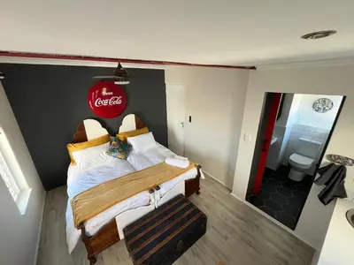a bedroom with a bed with a cocacola sign on the wall at Rocket Room in Stellenbosch