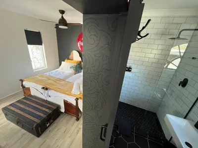 a bedroom with a bed and a bathroom with a shower at Rocket Room in Stellenbosch