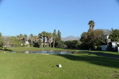 a park with a pond with a fountain in it at Charming Self-catering Apartment in Gordonʼs Bay