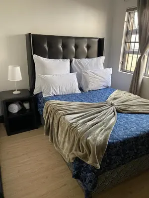 a bedroom with a large bed with a black headboard at Ludiz guest house in Parow