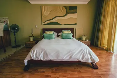 a bedroom with a large bed with a painting on the wall at Castellon Boutique Hotel in Table View