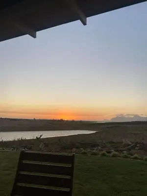 a bench sitting under a porch watching the sunset at Hermanus - Escape Wines - House on Wine & Protea farm in Lake Marina