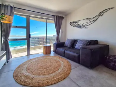 a living room with a couch and a large rug at Luxurious Ocean View Beachfront Apartment in Cape Town