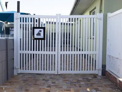 a white gate in front of a house at The Grey Hound in Strand
