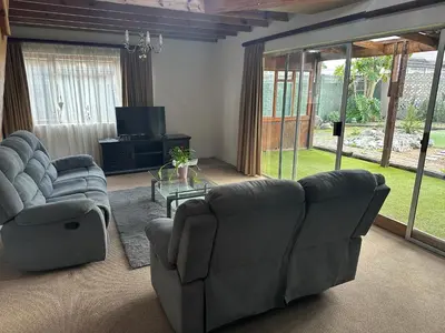 a living room with two couches and a tv at Suite Dreams Gorgeous Garden Holiday Home in Panorama