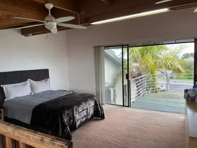 a bedroom with a bed and a sliding glass door at Suite Dreams Gorgeous Garden Holiday Home in Panorama
