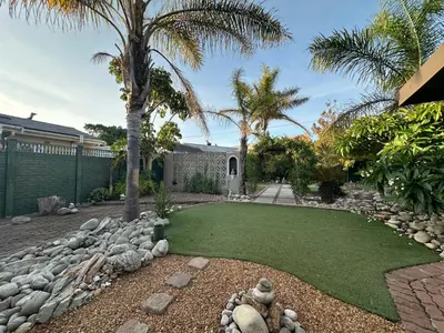 a garden with a lawn and palm trees at Suite Dreams Spacious Apartment in Panorama