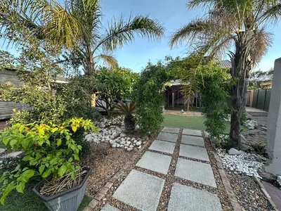 a garden with palm trees and a stone walkway at Suite Dreams Spacious Apartment in Panorama