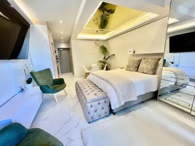 a bedroom with a large bed and a mirror at 34 On The Den in Stellenbosch