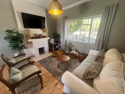 a living room with a white couch and a fireplace at The House Next Door in Stellenbosch