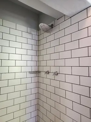 a bathroom with white tiled walls and a shower at Cosy en-suite room Stellenbosch in Stellenbosch