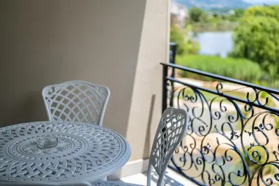 a table and two chairs on a balcony at 68 LErmitage Elegant Mountain Apartment in Franschhoek