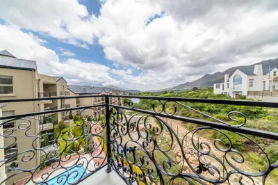 a balcony with a view of the mountains at 68 LErmitage Elegant Mountain Apartment in Franschhoek