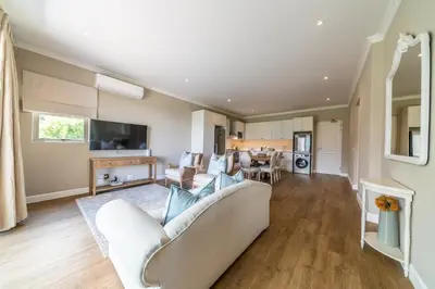 a living room with a couch and a table at 68 LErmitage Elegant Mountain Apartment in Franschhoek