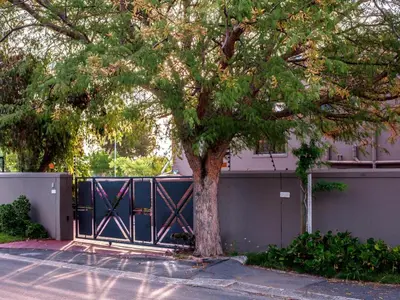 a gate with a tree in front of a building at Julinas Guesthouse in Panorama