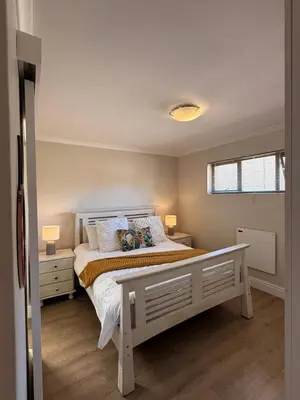a bedroom with a large white bed with two lamps at Little Haven in Kenridge