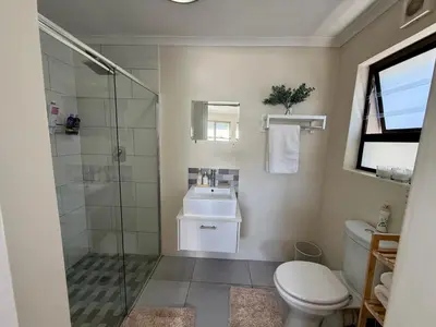 a bathroom with a shower and a toilet and a sink at Little Haven in Kenridge