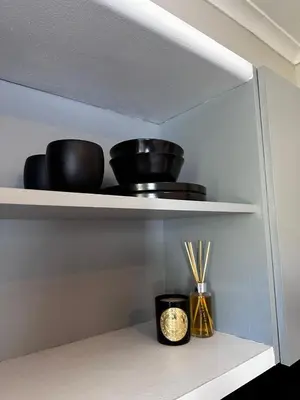 a shelf with bowls and chopsticks on it at Courtyard Hideaway in Kenridge