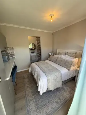 a bedroom with a large bed and a bathroom at Courtyard Hideaway in Kenridge