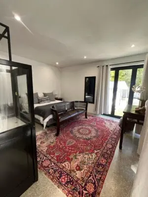 a living room with a bed and a rug at Helder Haven Cottage in Somerset West