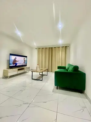 a living room with a green couch and a flat screen tv at Chill & Cozy shared apartment with Michael in Cape Town