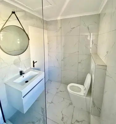 a white bathroom with a toilet and a sink at Chill & Cozy shared apartment with Michael in Cape Town