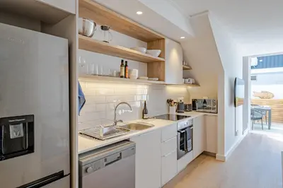 a kitchen with white cabinets and a sink at Whale Melody Love Hermanus in Hermanus