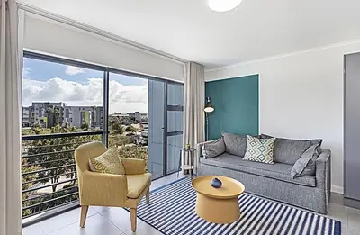 a living room with a couch and a table at Chic 1 bedroom apt in Century city in Cape Town