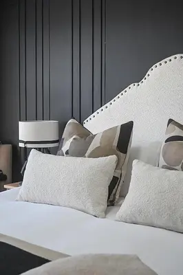 a bedroom with a white bed with pillows at SeeHUYS Boutique Bloubergstrand Beachfront Studio in Bloubergstrand