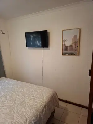 a bedroom with a bed and a flat screen tv on the wall at Chez Yves in Hoheizen