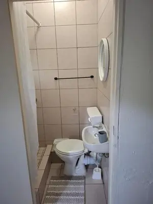 a small bathroom with a toilet and a sink at Chez Yves in Hoheizen