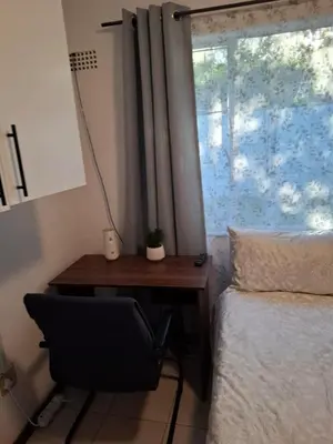 a bedroom with a desk next to a bed and a window at Chez Yves in Hoheizen