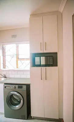 a kitchen with a washing machine and a microwave at 26 on Balfour Crescent in Silver Sands
