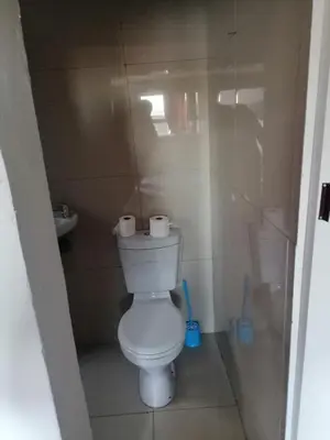 a bathroom with a toilet with two rolls of toilet paper at 72 the trout lodge in Goodwood