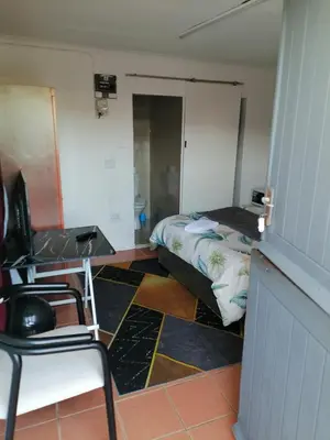 a room with a bed and a desk and a bed sidx sidx sidx at 72 the trout lodge in Goodwood