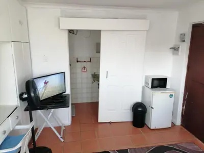 a room with a tv and a door with a television at 72 the trout H lodge in Goodwood