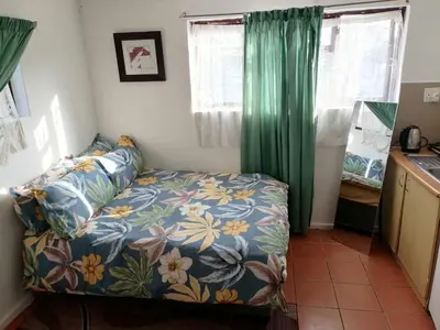 a bedroom with a bed with a floral bedspread at 72 the trout H lodge in Goodwood