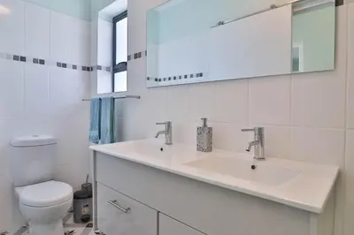 a white bathroom with a sink and a toilet at Thalassa in Bettyʼs Bay