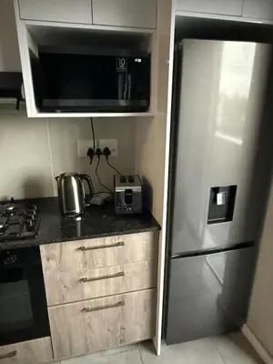 a kitchen with a stainless steel refrigerator and a microwave at Table Mountain View Apartment in Cape Town