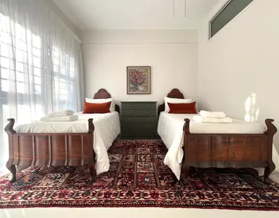 two beds in a bedroom with a rug at Bosch & Bloom in Stellenbosch