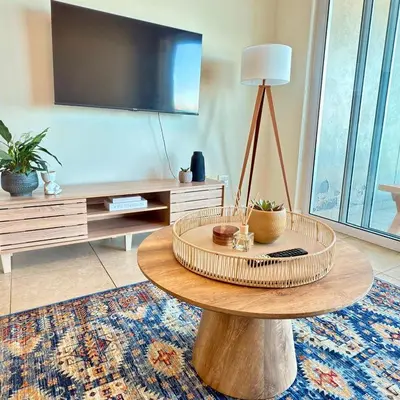 a living room with a table and a tv at Beautiful 2 Bedroom Apartment with Ocean Views, Bloubergstrand in Cape Town