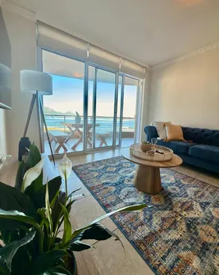 a living room with a couch and a coffee table at Beautiful 2 Bedroom Apartment with Ocean Views, Bloubergstrand in Cape Town