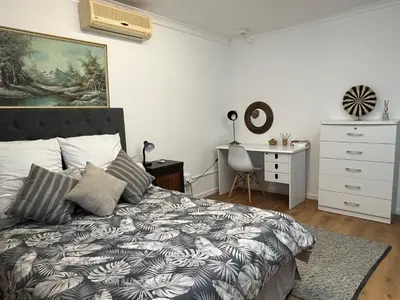 a bedroom with a bed and a dresser and a desk at Central Somerset Stay in Somerset West