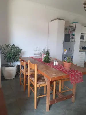 a dining room table with a red table cloth on it at Cosy Stay - Homestay with Linda & Garfield in Gordonʼs Bay