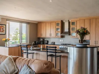 a kitchen with a couch and a kitchen island at Shores Keep - Self Catering Home in Hermanus