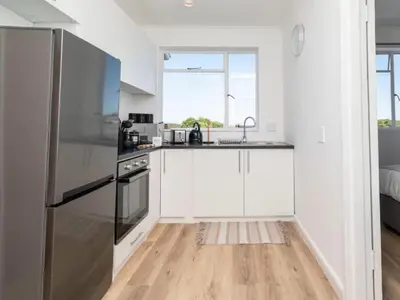 a kitchen with white cabinets and a stainless steel refrigerator at Atticus Self Catering Accommodation in Cape Town