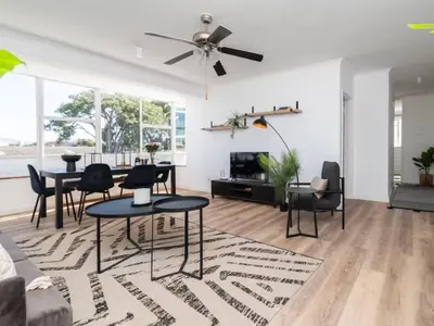 a living room with a table and chairs and a ceiling fan at Atticus Self Catering Accommodation in Cape Town