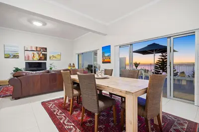 a living room with a wooden table and chairs at Suikerbossie 52 in Cape Town