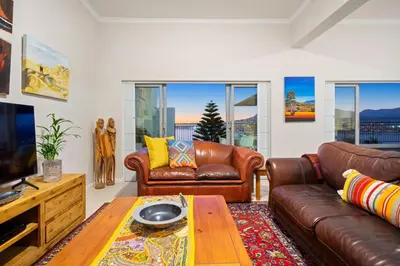 a living room with leather couches and a table at Suikerbossie 52 in Cape Town