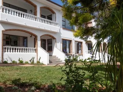 a large white house with a green yard at 5 Rembrandt Guesthouse in Somerset West
